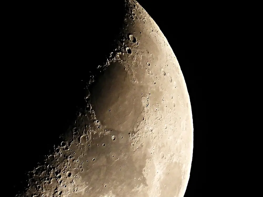 A closeup photo of the moon showing it's cratered surface in high resolution.